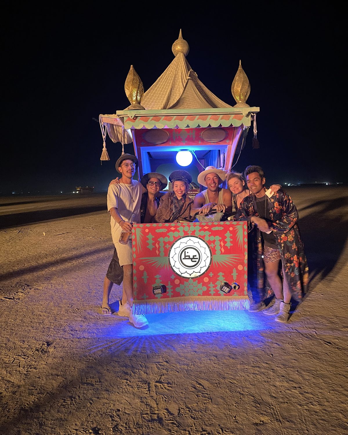 A group of friends gathered around Beautiful Engine at night